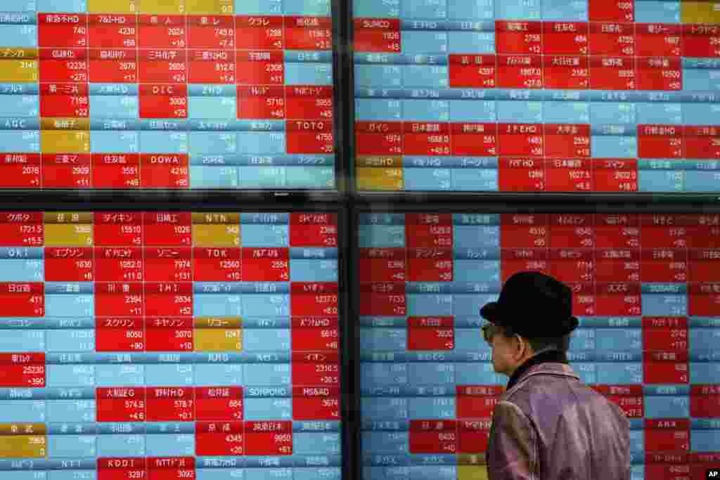 A man looks at an electronic stock board showing Japan&#39;s Nikkei 225 index at a securities firm in Tokyo.