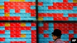 A man looks at an electronic stock board showing Japan's Nikkei 225 index at a securities firm in Tokyo Tuesday, Jan. 14, 2020. 