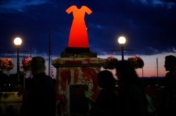 The statue of English explorer Captain James Cook was vandalized and removed from its base and tossed into the inner harbor and replaced with red handprints and a red dress, in Victoria, July 1, 2021.