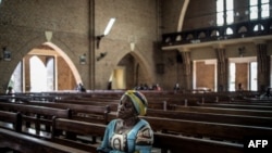 Une femme congolaise prie à la cathédrale Notre-Dame-de-Kinshasa de Kinshasa lors d'un service religieux le 29 décembre 2018.