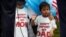 FILE - Boys wearing T-shirts calling for their parents not to be deported stand during a rally by immigration activists in Washington, D.C., Aug. 15, 2017. 
