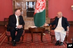 FILE - U.S. Secretary of State Mike Pompeo, left, meets with Afghan President Ashraf Ghani at the Presidential Palace in Kabul, Afghanistan, March 23, 2020.