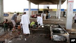 Des hommes récupèrent des débris après une manifestation à Khartoum, Soudan, le 26 septembre 2013. 