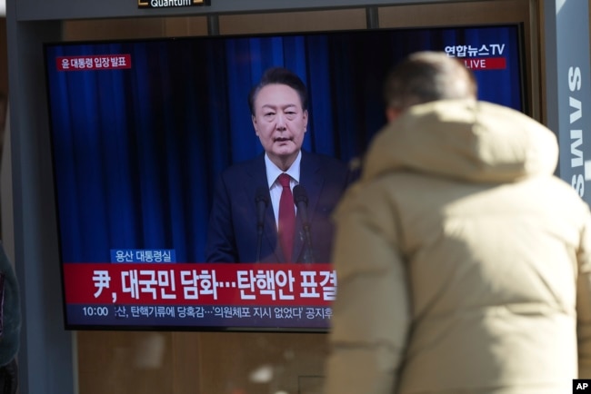 A man watches a TV screen showing the live broadcast of South Korean President Yoon Suk Yeol at the Seoul Railway Station in Seoul, South Korea, Dec. 7, 2024.