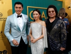 FILE - Author Kevin Kwan, right, and cast members Henry Golding and Constance Wu pose at the premiere for "Crazy Rich Asians" in Los Angeles, Aug. 7, 2018.