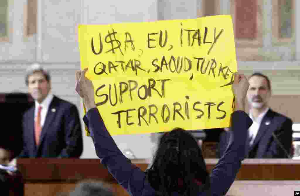 A peace activist protests at the end of statements given by U.S. Secretary of State John Kerry and Syrian National Coalition President Mouaz al-Khatib at Villa Madama in Rome, Feb. 28, 2013. 