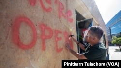 Sarayuth Komol, An owner of Shushi Aoi Restaurant, fixs plywood frames over the broken window after a night of protests and rioting near the White House in Washington.DC. May 31, 2020.