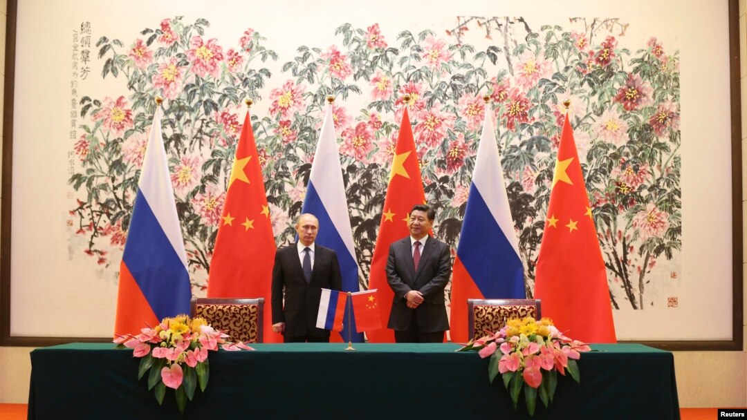 Presiden Rusia Vladimir Putin (kiri) dan Presiden China Xi Jinping saat menandatangani perjanjian kerjasama energi kedua negara di sela KTT APEC di Beijing, Minggu (9/11).