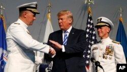 President Donald Trump (C) shakes hands with Coast Guard Adm. Karl Schultz (L) during a Change of Command ceremony at the U.S. Coast Guard Headquarters, June 1, 2018, in Washington. 