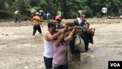 Venezolanos que huyen de la crisis en su país y cruzan el río Táchira, en la frontera con Colombia.
