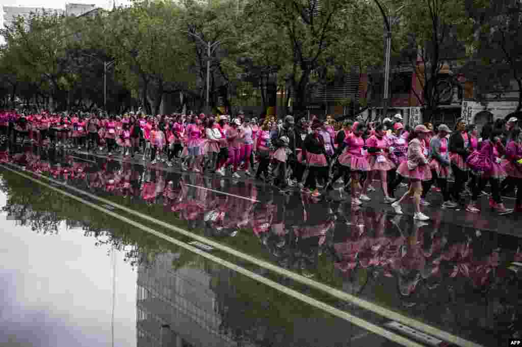 Runners participating in the "Barbie Run" race in the 3K, 5K, and 10K modalities run by a puddle of water along Reforma Avenue in Mexico City, Oct. 6, 2024.