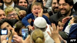 Le pape François au milieu d'une foule qu'il salue lors d'une audience au Vatican, le 6 mars 2015.  