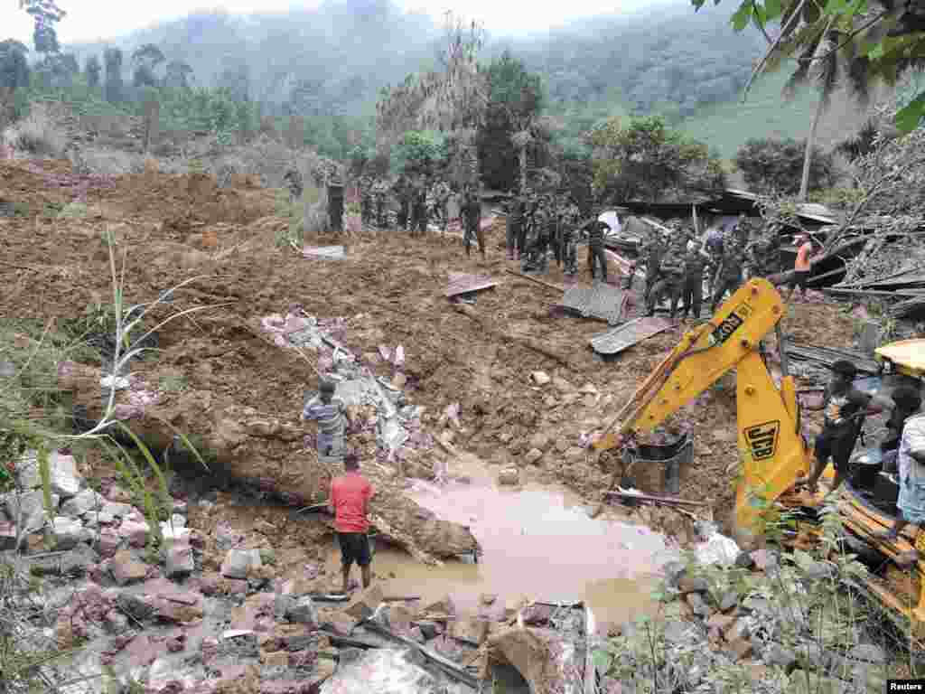 Rescue teams from the Sri Lankan military engage in a rescue operation at the site of a landslide at the Koslanda tea plantation in Badulla, Sri Lanka, Oct. 29, 2014. 