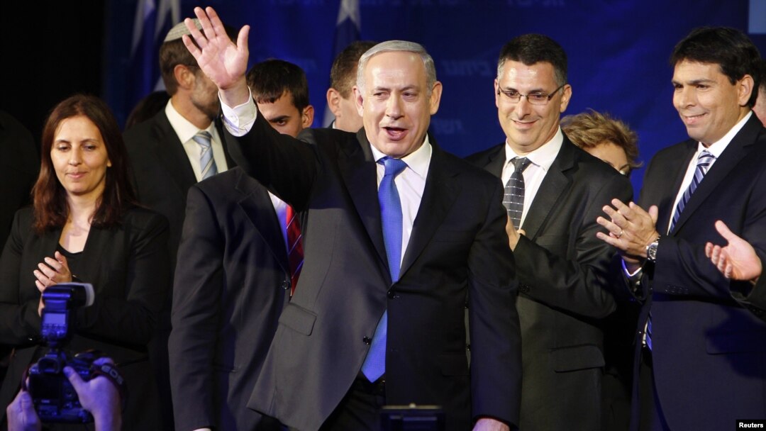 Israel's Prime Minister Benjamin Netanyahu waves to supporters as he stands with his party members at the Likud-Yisrael Beitenu headquarters in Tel Aviv January 23, 2013.