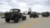 Vehículos militares y equipos, partes del sistema de defensa aérea ruso S-400, son vistos en la pista de aterrizaje al ser descargados de aviones rusos.