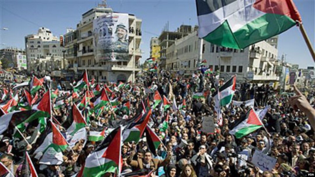 Warga Palestina melambaikan bendera dan menyerukan slogan dalam demonstrasi rekonsiliasi Hamas dan Fatah di Tepi Barat.
