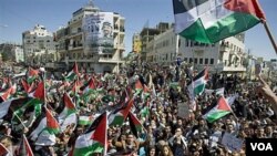 Warga Palestina melambaikan bendera dan menyerukan slogan dalam demonstrasi rekonsiliasi Hamas dan Fatah di Tepi Barat.