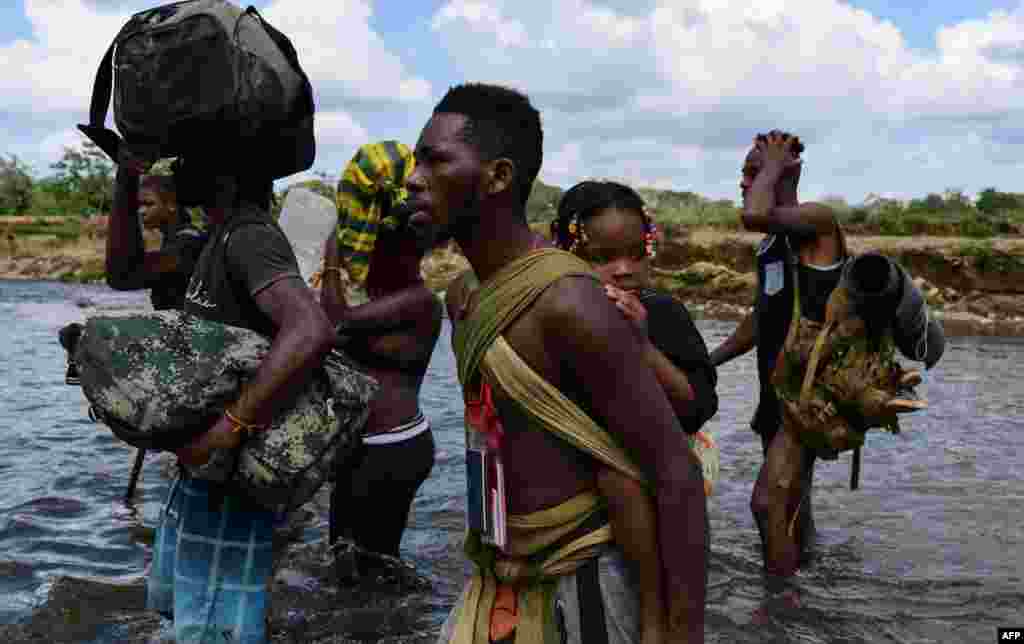 Migrants cross the Chucunaque River in the Darien Gap after walking for five days on their way to the U.S., in Bajo Chiquito village, Darien province, Panama, Feb. 10, 2021.