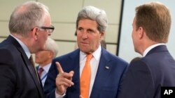 U.S. Secretary of State John Kerry, center, speaks with Dutch Foreign Minister Frans Timmermans, left, and Norwegian Foreign Minister Borge Brende, during a meeting of the North Atlantic Council in Foreign Ministers Session at NATO headquarters in Brussel, Belgium, June 25, 2014.