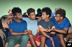 Eritrean under-20 soccer players Hermon Fessehaye Yohannes, Simon Asmelash Mekonen, Hanibal Girmay Tekle, and Mewael Tesfai Yosief talk together in a house where they are staying in Uganda.