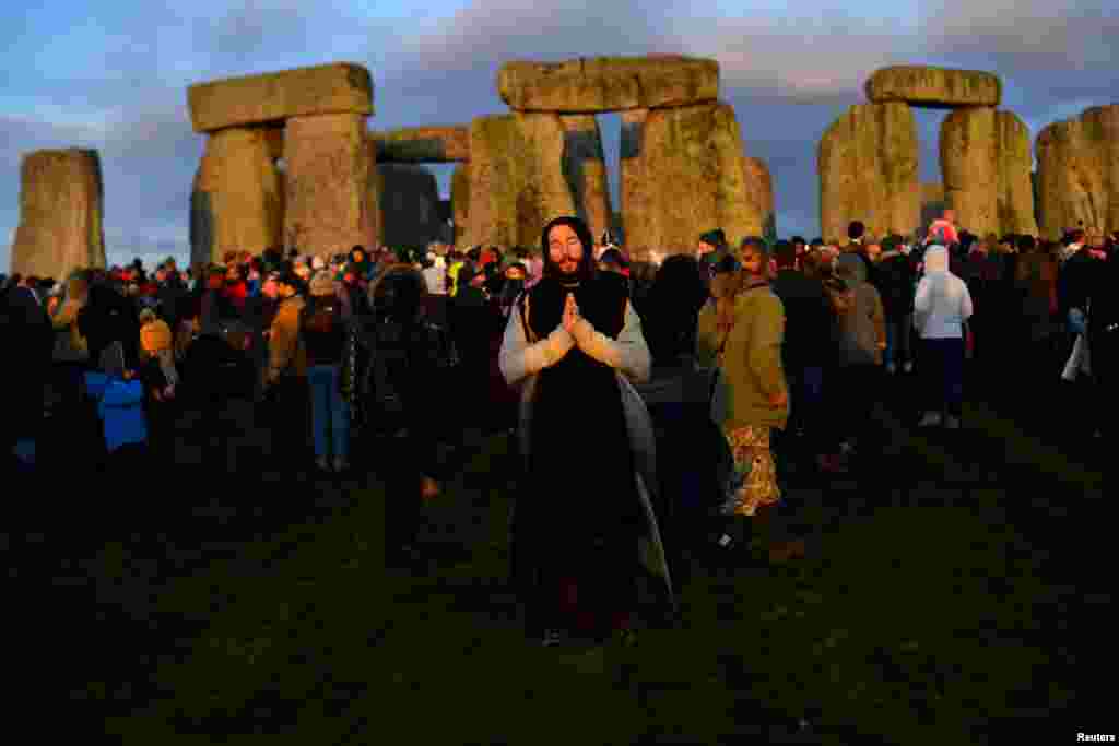 Revelers enjoy the sunrise as they welcome the winter solstice at Stonehenge stone circle in Amesbury, Britain.