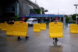 Staff members move barriers in front of a railway station of Wuhan on the first day of inbound train services resumed following the novel coronavirus disease (COVID-19) outbreak, in Wuhan, China, March 28, 2020.