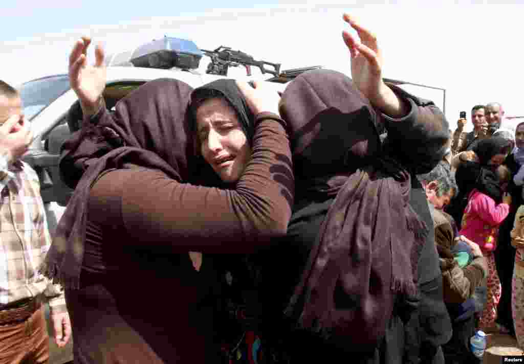 Members of the minority Yazidi sect who were newly released hug each other on the outskirts of Kirkuk April 8, 2015. More than 200 elderly and infirm Yazidis were freed on Wednesday by Islamic State militants who had been holding them captive since overru