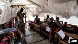 FILE - Mothers sit with their severely malnourished children inside a feeding and rehabilitation centre on October 23, 2017 in Tshikapa. 