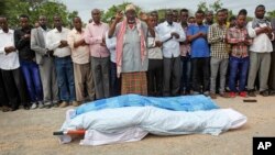 Mourners pray over the bodies of journalists Mohamed Abdikarim Moallim Adam, a reporter for the London-based Universal television, and Abdihakin Mohamed Omar, a producer for the Somali Broadcasting Corporation, at their funeral in Mogadishu, Somalia, July