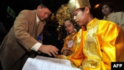 FILE - An Indonesian couple takes part in a mass interfaith wedding ceremony sponsored by an organizer and the Jakarta government in Jakarta on July 19, 2011.