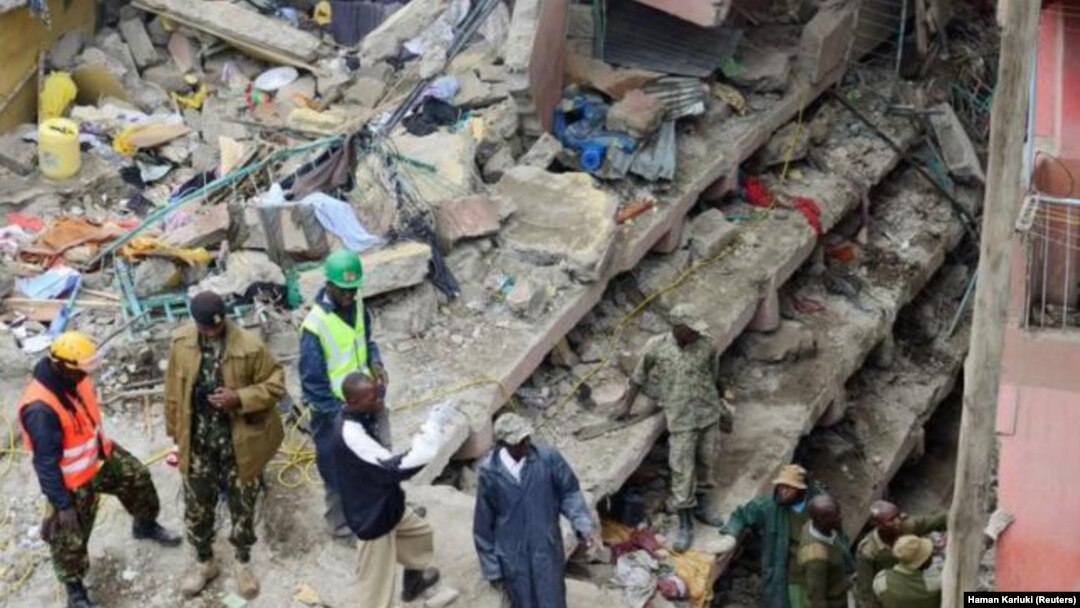 Petugas penyelamat mencari penghuni yang ditakutkan terperangkap dalam puing-puing bangunan yang ambruk akibat hujan deras di Nairobi, Kenya (30/4). (Reuters/Harman Kariuki)