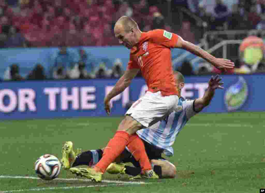 Argentina's Javier Mascherano, rear, tackles Netherlands' Arjen Robben during the World Cup semifinal soccer match between the Netherlands and Argentina at the Itaquerao Stadium in Sao Paulo Brazil, Wednesday, July 9, 2014. (AP Photo/Martin Meissner)