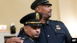 ຕຳຫຼວດຫໍລັດຖະສະພາ ສະຫະລັດ ສິບເອກ ອາກີລີໂນ ໂກແນລ, ຊ້າຍ ແລະ ຕຳຫຼວດຫໍລັດຖະສະພາ ສະຫະລັດ ສິບເອກ ແຮຣີ ດັນ ຢືນຫຼັງຈາກການໃຫ້ການຕໍ່ຄະນະກຳມະການສະພາຕໍ່າທີ່ຖືກເລືອກ ກ່ຽວກັບ ການໂຈມຕີວັນທີ 6 ມັງກອນ. ນະຄອນຫຼວງ ວໍຊິງຕັນ, 27 ກໍລະກົດ, 2021.