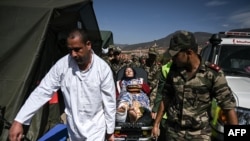 FILE - Military personnel transport on a gurney a survivor of the September 8 earthquake at a military field hospital in the village of Asni near Moulay Brahim in al-Haouz province in the High Atlas mountains of central Morocco on September 11, 2023.