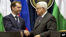 Palestinian President Mahmoud Abbas, right, and Russian President Dmitry Medvedev, left, shake hands at the end of a press conference in the West Bank town of Jericho, 18 Jan 2011