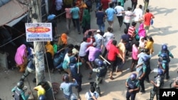Bangladeshi security personnel charge to disperse garment workers protesting in Gazipur on Nov. 9, 2023, after the Minimum Wage Board authority declared the minimum wage of 12,500 taka ($113) for garment workers.