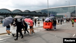 Protesters build barricades outside the terminals at Hong Kong International Airport, in Hong Kong, Sept. 1, 2019. 