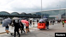 Protesters build barricades outside the terminals at Hong Kong International Airport, in Hong Kong, Sept. 1, 2019. 