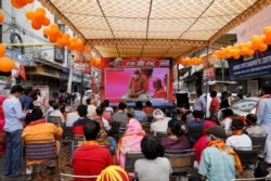 People watch a live screening of the stone laying ceremony of the Ram Temple by Prime Minister Narendra Modi in Ayodhya, in New Delhi, India, Aug. 5, 2020.