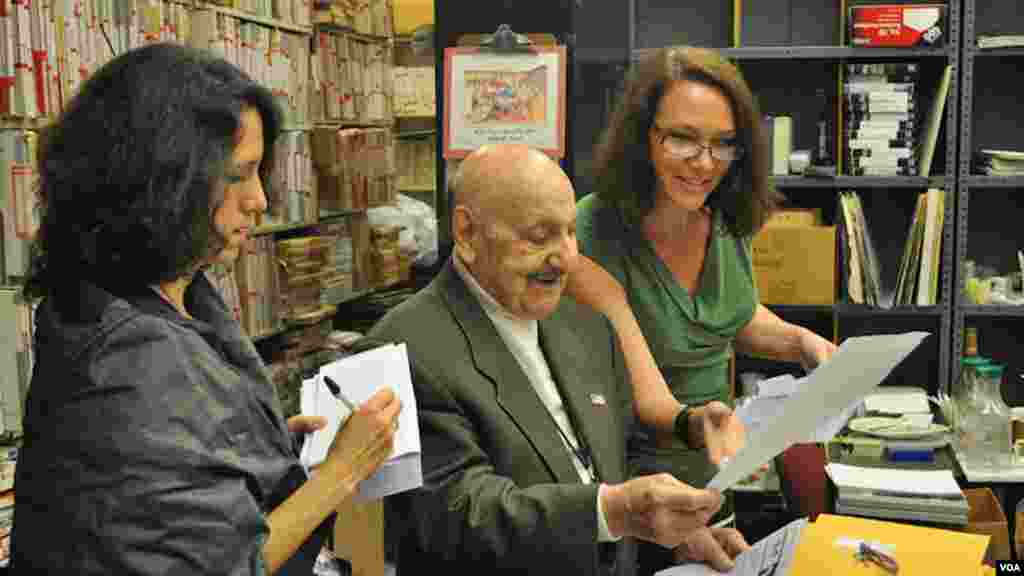 Leo and "Music Time for Africa" host Heather Maxwell (right) look over a new piece of mail written by a fan of the popular music show that Leo started 47 years earlier. It is VOA's longest running English language program.