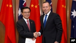 PM Australia Tony Abbott (kanan) berjabat tangan dengan Menteri Perdagangan China Gao Hucheng usai penandatanganan perjanjian perdagangan bebas kedua negara di Canberra, Rabu (17/6).