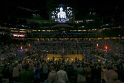 Fans stand for a moment of silence honoring Kobe Bryant before an NBA basketball game between the Orlando Magic and the LA Clippers in Orlando, Florida, Jan. 26, 2020.