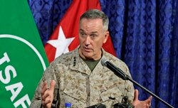 FILE - Top U.S. military commander in Afghanistan, Joseph Dunford, talks to media representatives at the ISAF headquarters in Kabul, June, 18, 2013.
