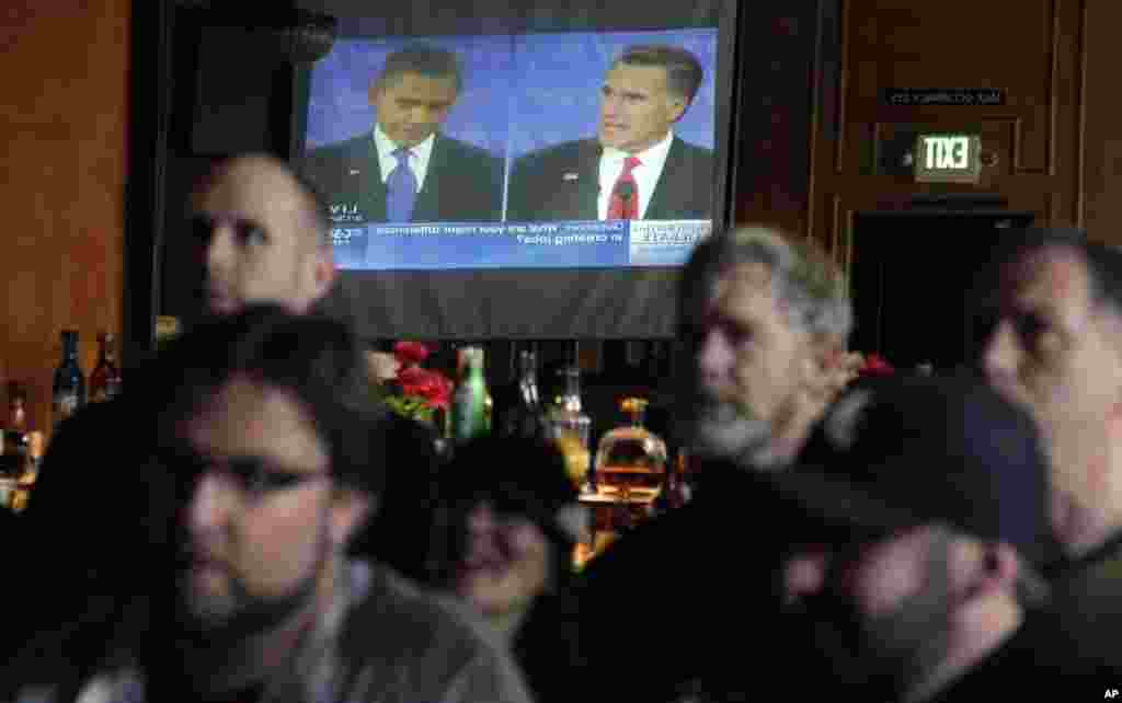 Pengunjung sebuah bar, Havana Social Club, di Seattle menonton Presiden Obama berdebat dengan penantangnya, Mitt Romney (3/10).