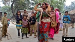 Anggota keluarga berduka atas kematian saudaranya akibat minum miras oplosan di kota kecil Malihabad, negara bagian Uttar Pradesh, India (13/1). 