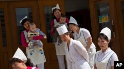 지난 2013년 5월 평양 유아원에 유엔 프로그램을 통해 영양제를 공급한 인도주의 단체 대표들에게 간호사들이 인사하고 있다. 