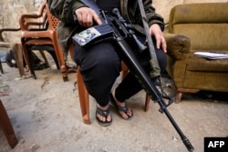 Said, a 23-year-old Palestinian militant from the "Tulkarm Brigade", sits with his weapon at the Nur Shams camp for Palestinian refugees, where Israeli raids have been conducted, near the occupied West Bank city of Tulkarm on January 8, 2024.