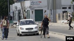 Rebeldes chequean un vehículo en un puesto de control en Trípoli.