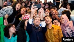 Menteri Luar Negeri John Kerry mengambil 'selfie' bersama sejumlah mahasiswa/i Indonesia sebelum berpidato di Jakarta (16/2). (Reuters/Evan Vucci)