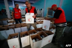 Iraqi Red Cresent Society employees pack humanitarian aid bound for Egypt and then onto the Palestinians of the Gaza Strip, at a warehouse in Baghdad on October 23, 2023, amid the ongoing battles between Israel and the Palestinian group Hamas.